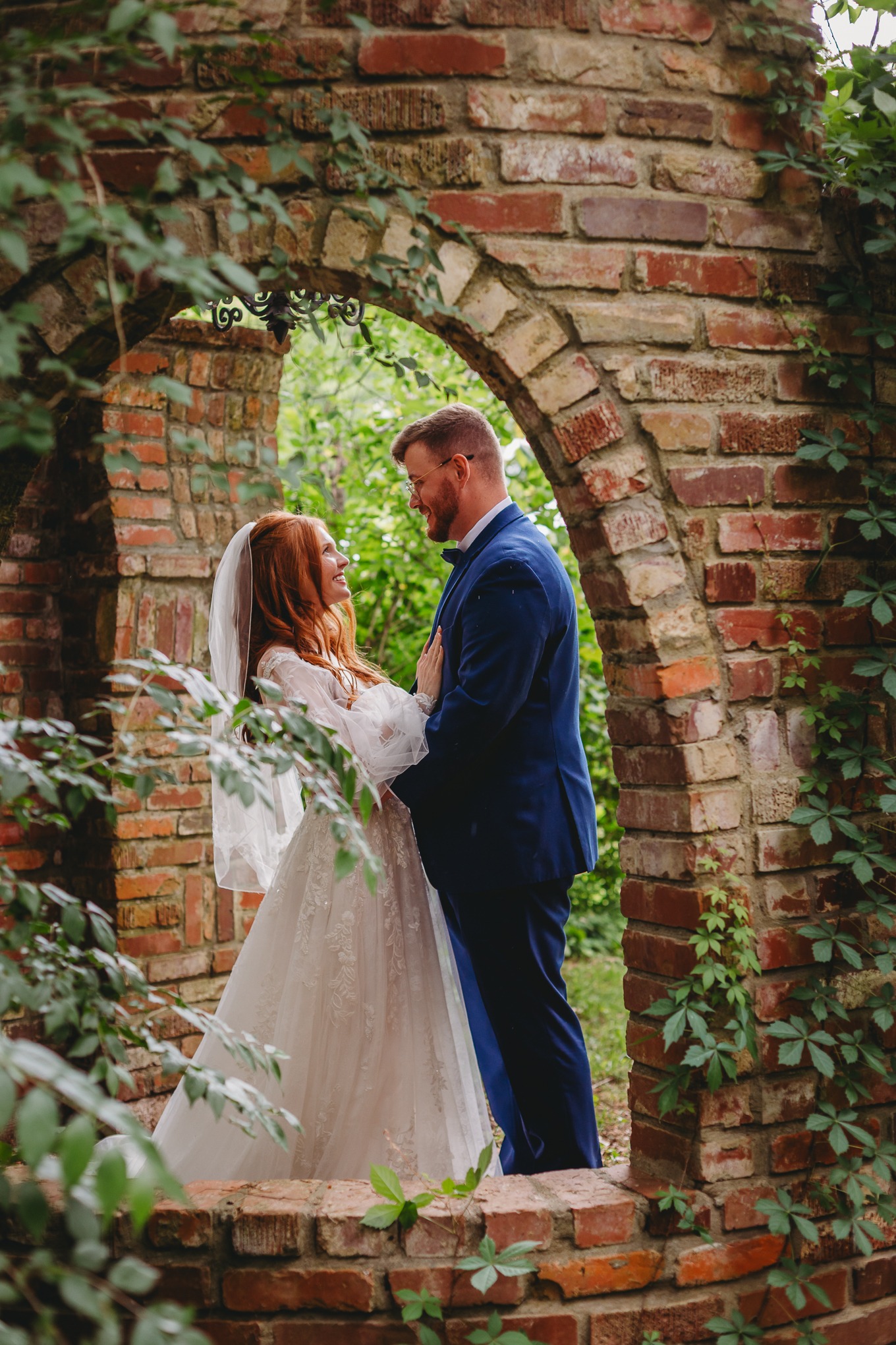 A newlywed couple beneath the estate's historic brick arch