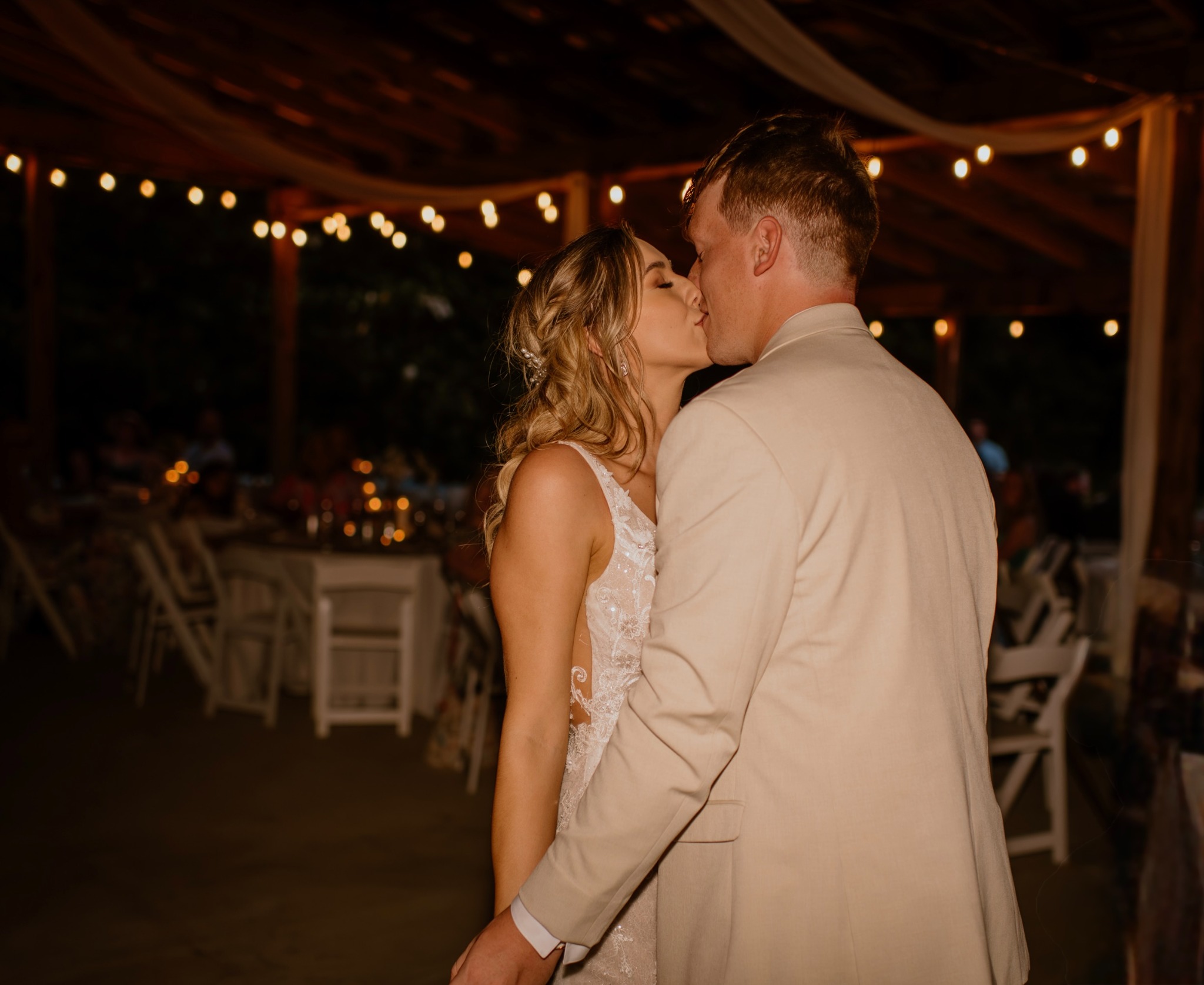 A newlywed couple beneath the pavilion lights